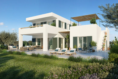Ejemplo de fachada de casa blanca y gris mediterránea de tamaño medio de dos plantas con revestimiento de aglomerado de cemento, tejado plano, tejado de varios materiales y escaleras