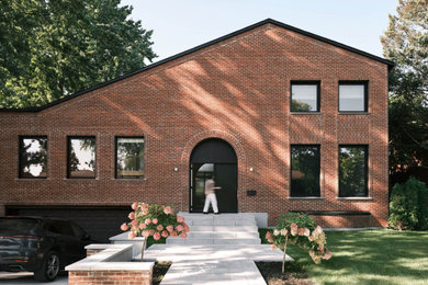 Example of a large trendy red split-level brick exterior home design in Montreal