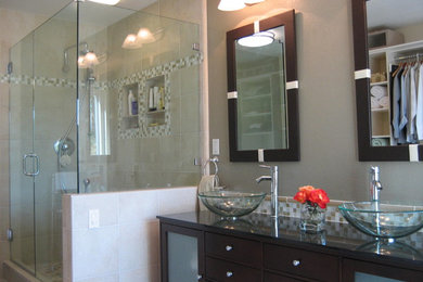 Inspiration for a mid-sized transitional master bathroom in San Francisco with flat-panel cabinets, dark wood cabinets, a corner shower, beige tile, stone tile, beige walls, travertine floors, a vessel sink, engineered quartz benchtops, beige floor and a hinged shower door.