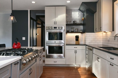 Inspiration for a transitional beige floor kitchen remodel in New York with a single-bowl sink, shaker cabinets, gray cabinets, quartzite countertops, white backsplash, subway tile backsplash, stainless steel appliances and an island