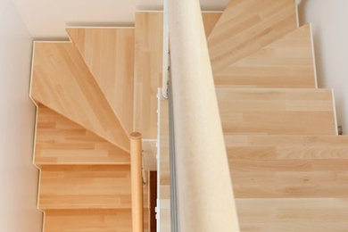 Aménagement d'un petit escalier sans contremarche scandinave en U avec des marches en bois.