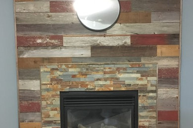 Mountain style carpeted living room photo in Other with blue walls, a standard fireplace, a stone fireplace and no tv