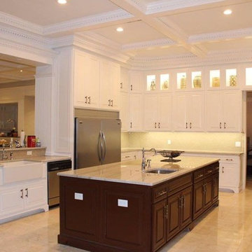 Transitional white kitchen cabinets, coiffured ceiling and oversized island.