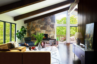 Example of a mid-century modern exposed beam and wood wall family room design in Chicago with a standard fireplace and a stone fireplace