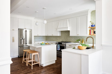 Example of a mid-sized classic u-shaped dark wood floor and brown floor enclosed kitchen design in DC Metro with an undermount sink, shaker cabinets, white cabinets, green backsplash, subway tile backsplash, stainless steel appliances, an island and white countertops