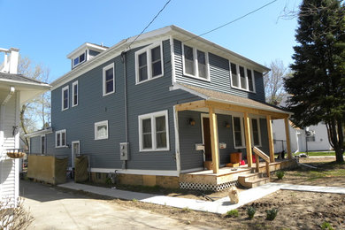 Mid-sized blue two-story vinyl house exterior idea in Other with a hip roof and a shingle roof