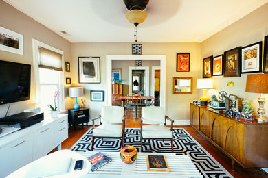 Inspiration for a small modern enclosed medium tone wood floor living room remodel in Charlotte with beige walls and a wall-mounted tv