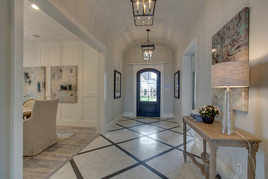 На фото: прихожая среднего размера в стиле неоклассика (современная классика) с белыми стенами, мраморным полом, одностворчатой входной дверью, входной дверью из темного дерева и белым полом с