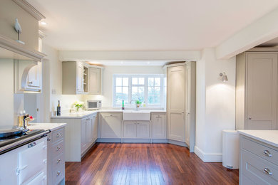 Ejemplo de cocina comedor grande con fregadero sobremueble, armarios estilo shaker, puertas de armario grises, encimera de cuarcita, electrodomésticos blancos, suelo de madera oscura, suelo marrón y encimeras blancas