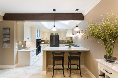 Inspiration for a mid-sized timeless galley ceramic tile and beige floor eat-in kitchen remodel in Other with an undermount sink, shaker cabinets, white cabinets, gray backsplash, glass tile backsplash, black appliances and a peninsula