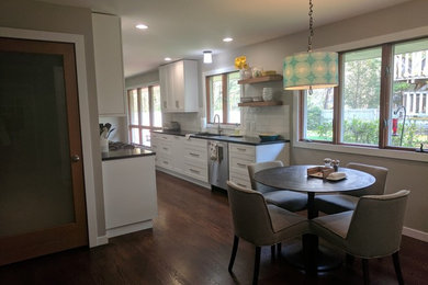 Mid-sized transitional galley dark wood floor and brown floor eat-in kitchen photo in Other with an undermount sink, shaker cabinets, white cabinets, granite countertops, white backsplash, ceramic backsplash and stainless steel appliances