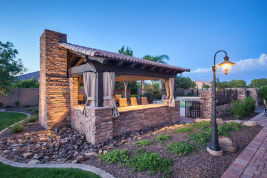 Example of a large classic backyard concrete paver patio kitchen design in Phoenix with a gazebo