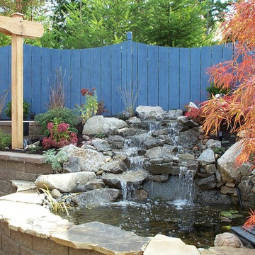Terraced backyard with raised pond and greenhouse