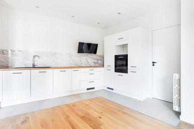Foto di una grande cucina minimal con top in legno, elettrodomestici neri, pavimento marrone e top marrone
