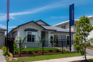 Photo of a mid-sized beach style one-storey grey house exterior in Gold Coast - Tweed with a gable roof and a metal roof.