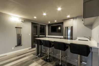 Inspiration for a contemporary medium tone wood floor seated home bar remodel in Seattle with an undermount sink, gray cabinets and white countertops