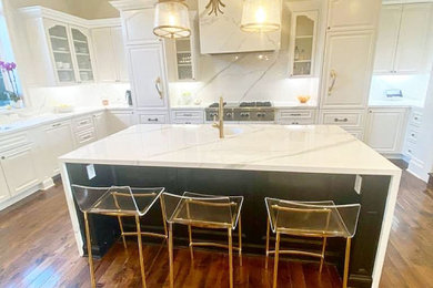 Inspiration for a large modern u-shaped dark wood floor and brown floor kitchen remodel in Jacksonville with a drop-in sink, beaded inset cabinets, white cabinets, quartz countertops, white backsplash, quartz backsplash, an island and white countertops