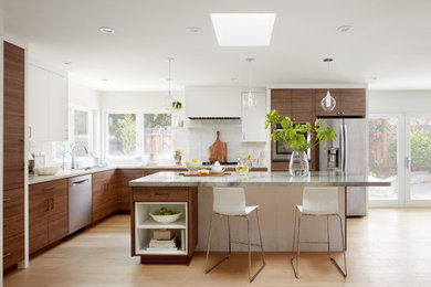 Example of a mid-sized minimalist l-shaped light wood floor open concept kitchen design in Atlanta with a single-bowl sink, flat-panel cabinets, medium tone wood cabinets, quartzite countertops, white backsplash, ceramic backsplash, stainless steel appliances, an island and multicolored countertops