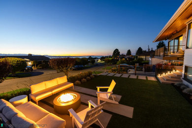 Example of a large front yard concrete paver patio design in Seattle with a fire pit