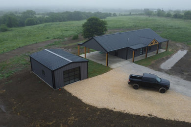Example of a large gray one-story metal exterior home design in Dallas with a metal roof and a black roof