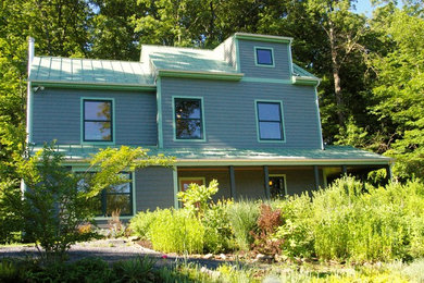 Trendy green three-story concrete fiberboard exterior home photo in DC Metro with a metal roof