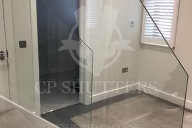 エセックスにあるラグジュアリーな広いモダンスタイルのおしゃれな廊下 (白い壁、磁器タイルの床) の写真