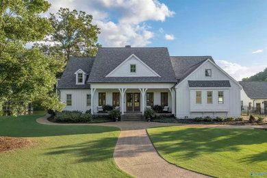 Mid-sized cottage white two-story mixed siding and board and batten house exterior idea in Birmingham with a shingle roof and a black roof