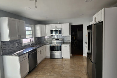 Eat-in kitchen - mid-sized modern u-shaped ceramic tile and beige floor eat-in kitchen idea in Philadelphia with an undermount sink, shaker cabinets, white cabinets, granite countertops, multicolored backsplash, mosaic tile backsplash, stainless steel appliances, no island and gray countertops