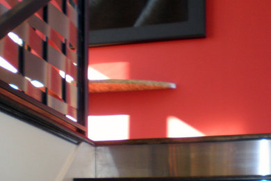 Foto de escalera contemporánea con escalones de madera y contrahuellas de metal
