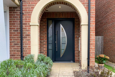 На фото: входная дверь в классическом стиле с одностворчатой входной дверью и серой входной дверью