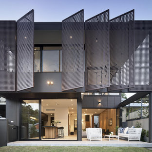 This is an example of a modern two-storey grey house exterior in Brisbane with a flat roof.