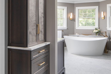 Inspiration for an expansive transitional master bathroom in Other with recessed-panel cabinets, a freestanding tub, gray tile, marble, marble floors, an undermount sink, granite benchtops, a sliding shower screen, an enclosed toilet, a freestanding vanity, dark wood cabinets, a two-piece toilet, grey walls, grey floor, white benchtops and a single vanity.
