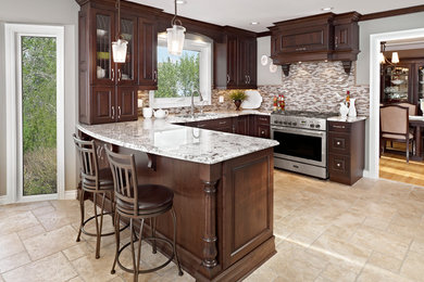 Inspiration for a mid-sized timeless u-shaped ceramic tile and beige floor eat-in kitchen remodel in Edmonton with an undermount sink, raised-panel cabinets, dark wood cabinets, granite countertops, beige backsplash, mosaic tile backsplash, stainless steel appliances, a peninsula and beige countertops