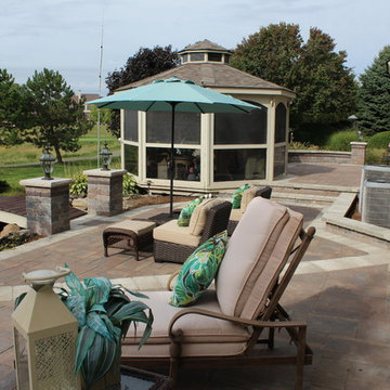 Expansive hardscape with green landscaping at residence overlooking golf course