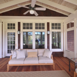 This is an example of a large craftsman screened-in back porch design in Boston with decking and a roof extension.