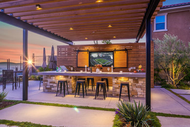 Mid-sized minimalist backyard concrete patio kitchen photo in Orange County with a pergola