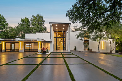 Contemporary white two-story house exterior idea in Dallas with a shed roof