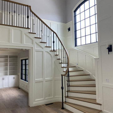 Painted and stained entry staircase with white painted wainscoting