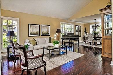 Inspiration for a mid-sized transitional open concept dark wood floor and brown floor living room remodel in Orange County with beige walls