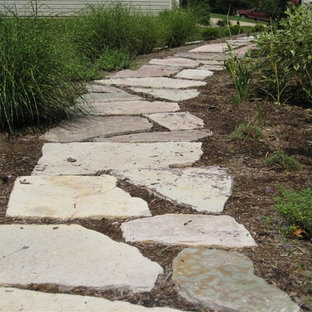 Idées déco pour un jardin à la française latéral classique l'été avec une exposition ombragée, des pavés en pierre naturelle et un chemin.