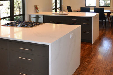 Mid-sized minimalist u-shaped medium tone wood floor eat-in kitchen photo in Other with a single-bowl sink, flat-panel cabinets, brown cabinets, quartz countertops, stainless steel appliances and two islands