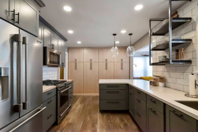 Example of a mid-sized urban u-shaped vinyl floor and brown floor eat-in kitchen design in Other with an undermount sink, shaker cabinets, gray cabinets, solid surface countertops, white backsplash, subway tile backsplash, stainless steel appliances, no island and white countertops