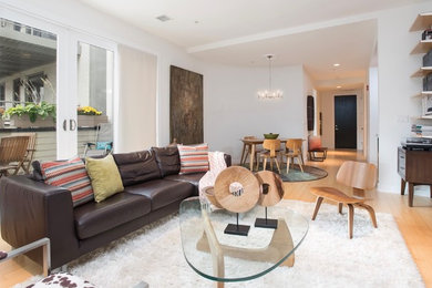 Inspiration for a mid-sized 1950s light wood floor living room library remodel in New York with white walls and a tv stand