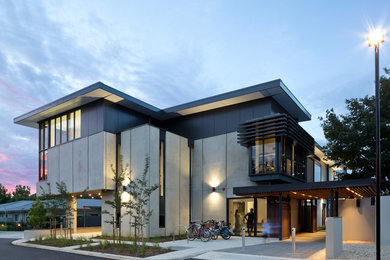 Esempio della facciata di un appartamento grande grigio moderno a due piani con rivestimento in metallo, tetto piano e copertura mista