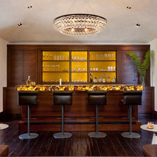 ロサンゼルスの地中海スタイルのおしゃれな着席型バー (濃色木目調キャビネット、黄色いキッチンパネル、濃色無垢フローリング、黄色いキッチンカウンター、フラットパネル扉のキャビネット) の写真