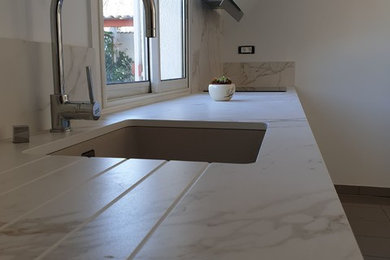 Réalisation d'une cuisine ouverte linéaire minimaliste de taille moyenne avec un plan de travail en quartz modifié.
