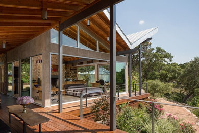 Inspiration for an expansive midcentury backyard patio in Austin with decking and a roof extension.