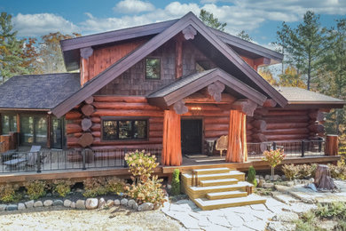 Example of a mid-sized mountain style brown three-story wood and board and batten exterior home design in Other with a shingle roof and a brown roof