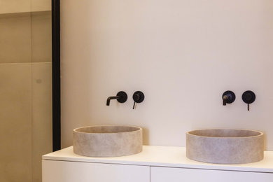 Medium sized contemporary family bathroom in London with flat-panel cabinets, white cabinets, limestone worktops, white worktops, double sinks and a floating vanity unit.
