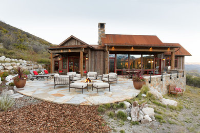 Inspiration for a mid-sized rustic backyard stone patio remodel in Denver with a fire pit and no cover